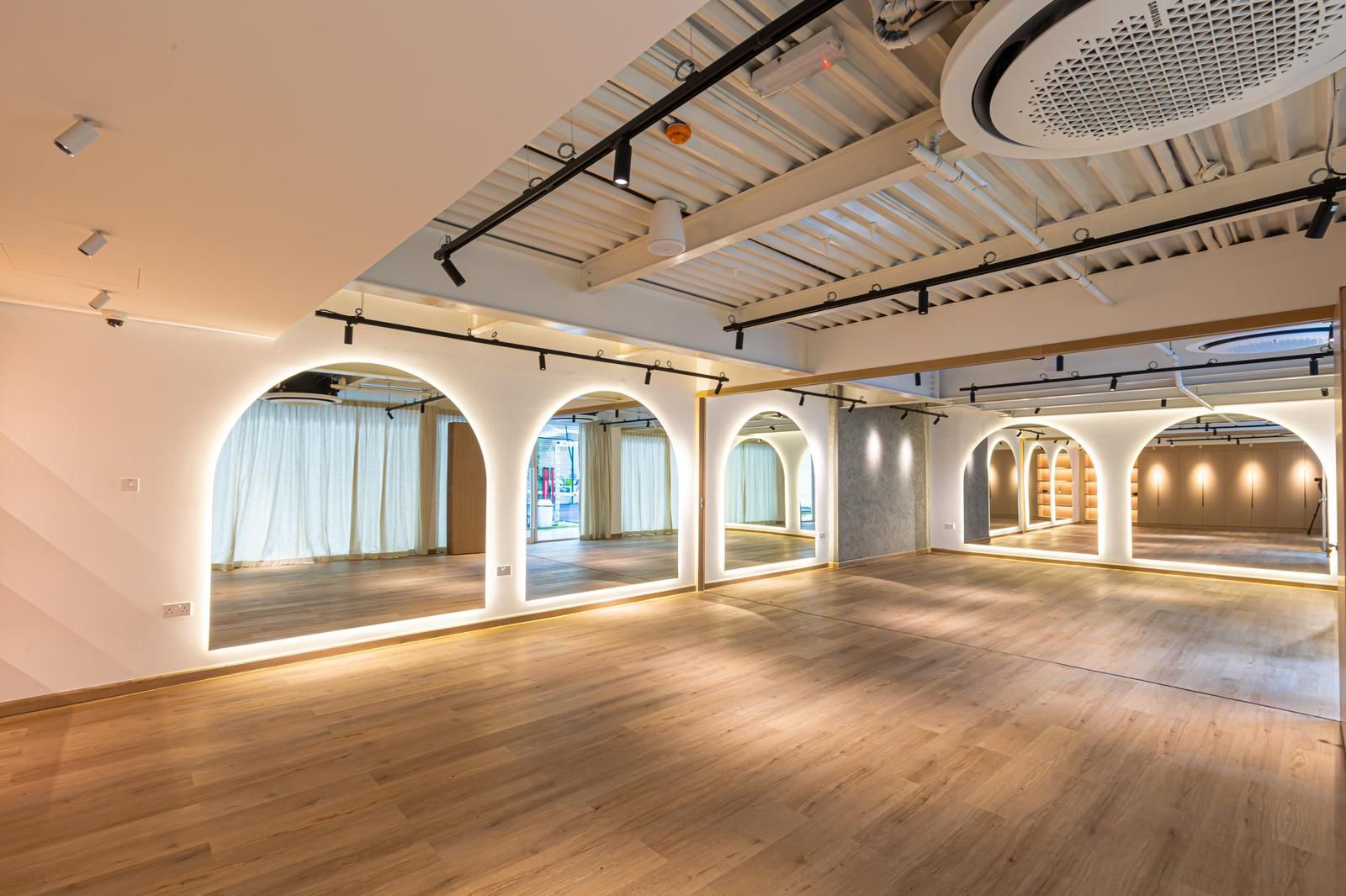 La salle Red Studio à Dubai, arches lumineuses, miroirs et parquet bois